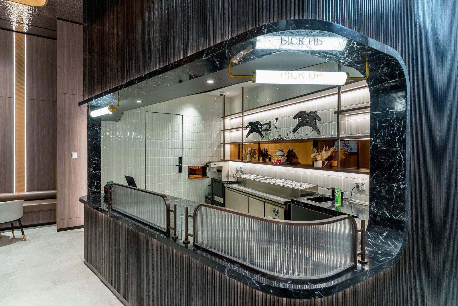Black marble servery counter with fluted glass screens and brass detailing