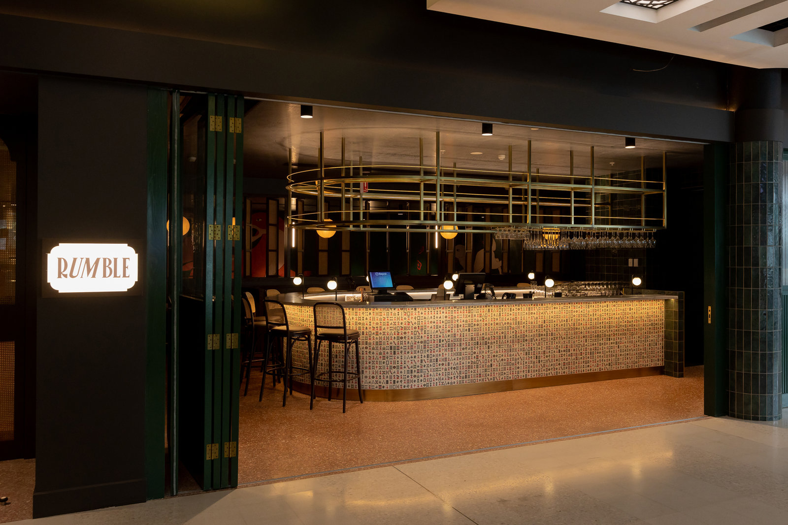 Cocktail bar with brass canopy and mosaic-tiled counter