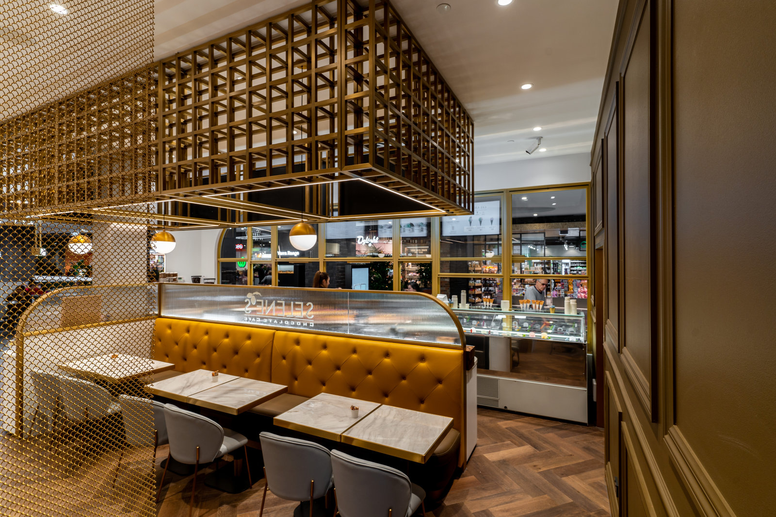 Chocolate café with brass lattice ceiling feature and leather banquette